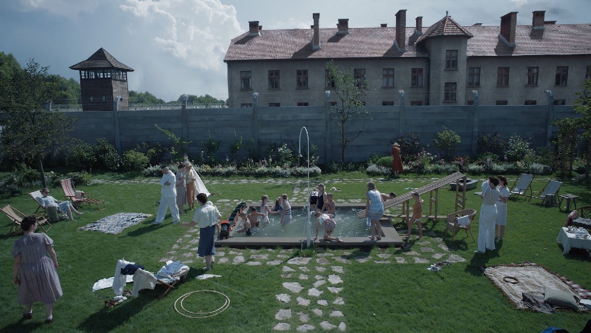 The Höss family and friends enjoy a the pool in the garden, separated from Auschwitz by a tall concrete wall.