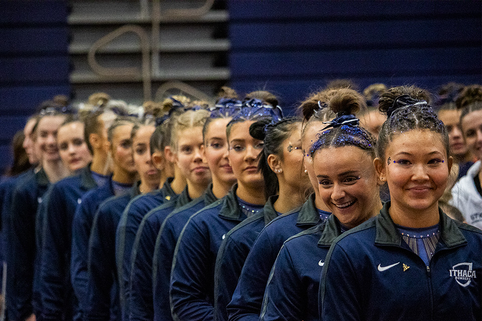 From front, sophomore beam/floor Corey Foster, junior beam/floor Caitlin Pellegrino and their bomber teammates lineup in anticipation of the beginning of the 2024 NCGA Regional Championships on March 9.