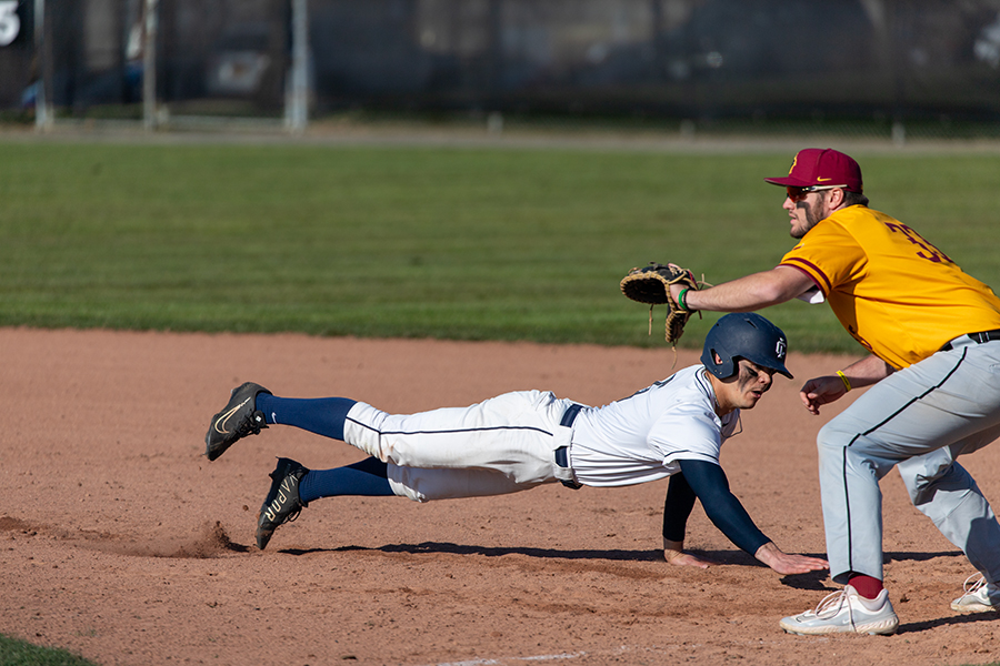 Junior center fielder Collin Feeney dives back to base after the pitcher tries to pick him off in the Bombers victory against the Cardinals. Feeney hit 3 for 5 today at the plate and was able to score a run.