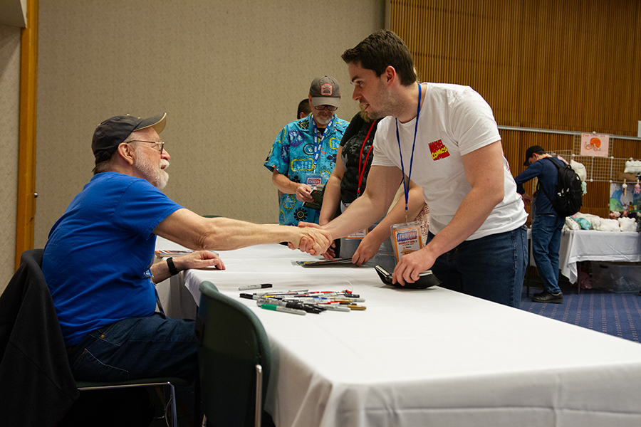 From left, comic book writer Walt Simonson shakes hands with Travis Anstee at Ithacon in Emerson Suites April 28. The annual comic and cosplay convention draws in creators and fans of the medium from across the region. 