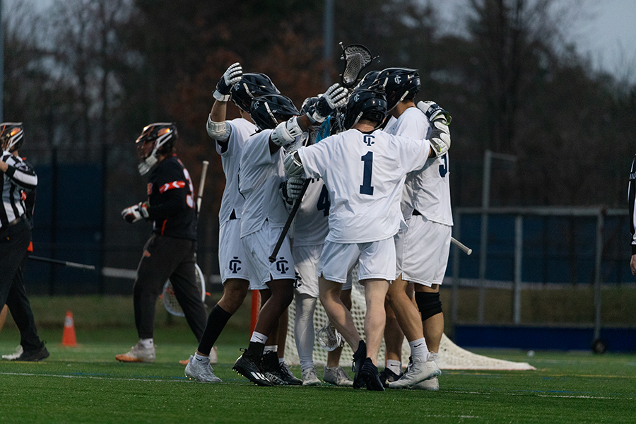 The Bombers embrace after scoring one of 10 goals against the Rochester Institute of Technology Tigers on April 10. The Bombers would fall 16–10. 