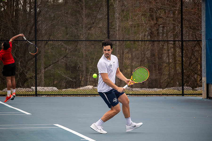 Senior Nicholas Luiz gears back as he gets ready to hit the ball. Luiz won both his doubles and singles match against the Red Dragons.