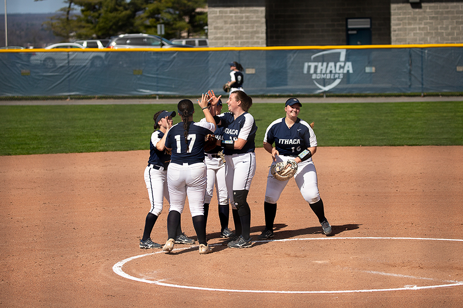 The Ithaca College softball team surround junior pitcher Anna Cornell after another great pitching performance in the Bombers 8–0 victory against the Alfred University Saxons on April 9.