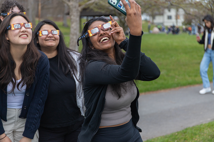 From left to right, first-year student Hee Jin Cho, Student Success Coach Trisha Mukherjee and graduate student Vaishnavi Devi Kumar  take a selfie in their solar eclipse glasses.