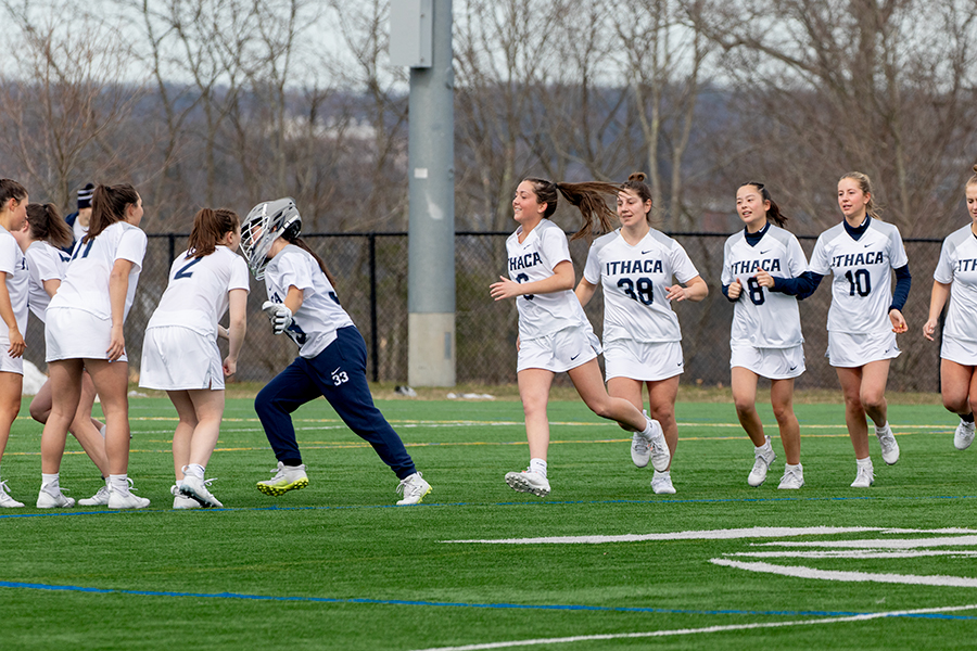The Ithaca College womens lacrosse team runs across Higgins Stadium with smiles. The Bombers extended their win streak to 10 games with an 18–3 victory over the Vassar College Brewers on April 19.