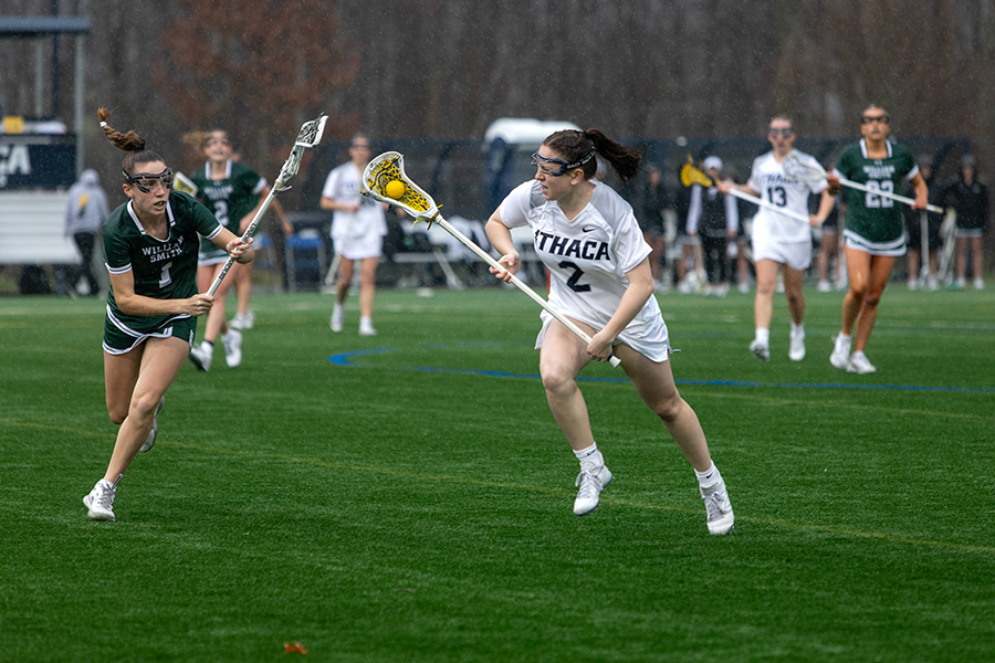 Junior defense Kaitlyn Russell rushes past a pursuing Herons senior attack Emily Griffin on April 10. This was the first win for the Bombers against the Herons since 2021.