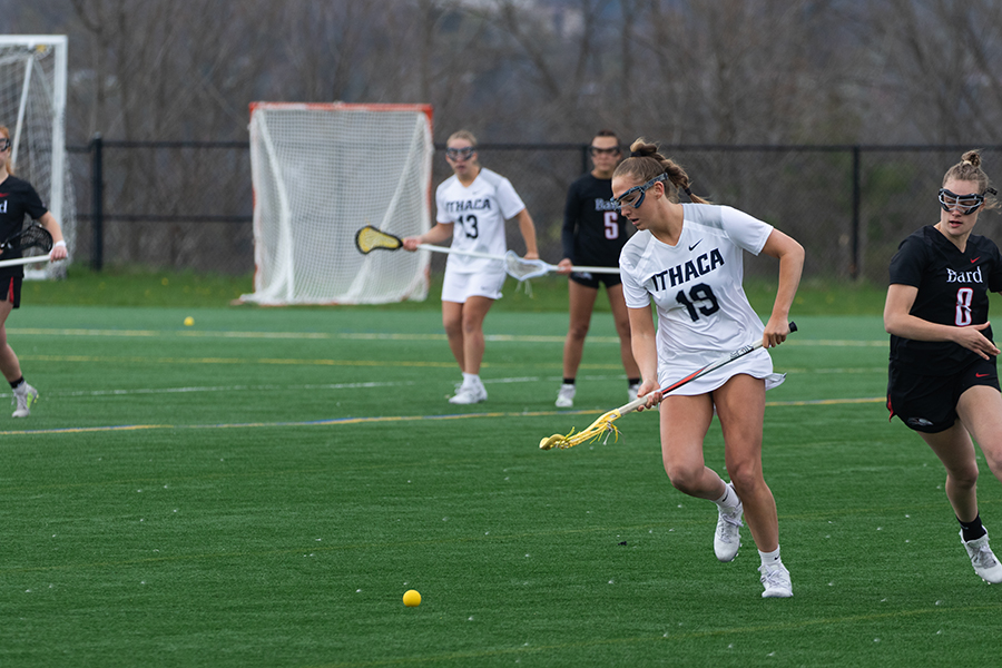 Senior midfielder Caroline Wise chases towards a ground ball as Raptors graduate student defender Paige Gregg follows closely April 20 against the Bard College Raptors.
