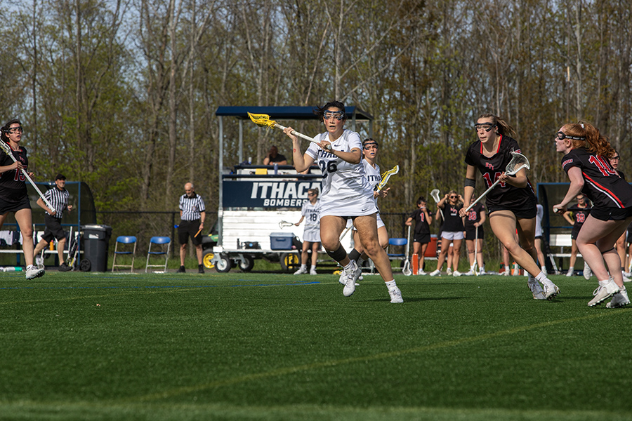 Junior midfielder Juliana Esposito looks to pass the ball as multiple Engineer defenders surround her on May 3. The Bombers would go on to win 14–7 to advance to the Liberty League Championship.