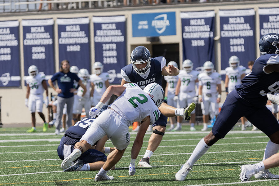 Senior kicker Derek Baldin attempts the extra point, while the Gulls' graduate student defensive back Johnny Carreiro tries to block the kick. The matchup between the Bombers and the Gulls was a low-scoring contest, with the Gulls winning 13-7.