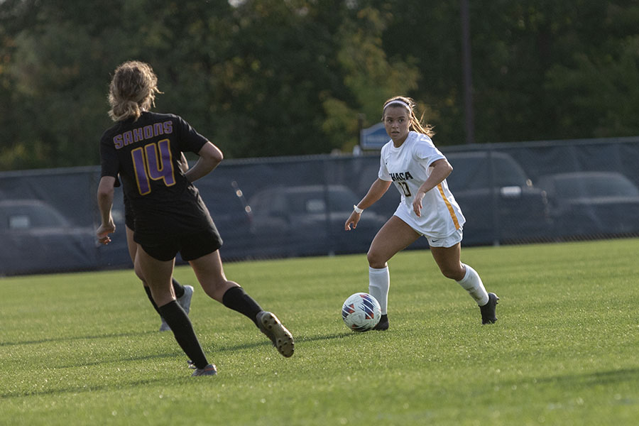 Junior midfielder Kaelyn Fernandez dribbles the ball while Saxons' first-year student defender Amber Bates moves to challenge her.