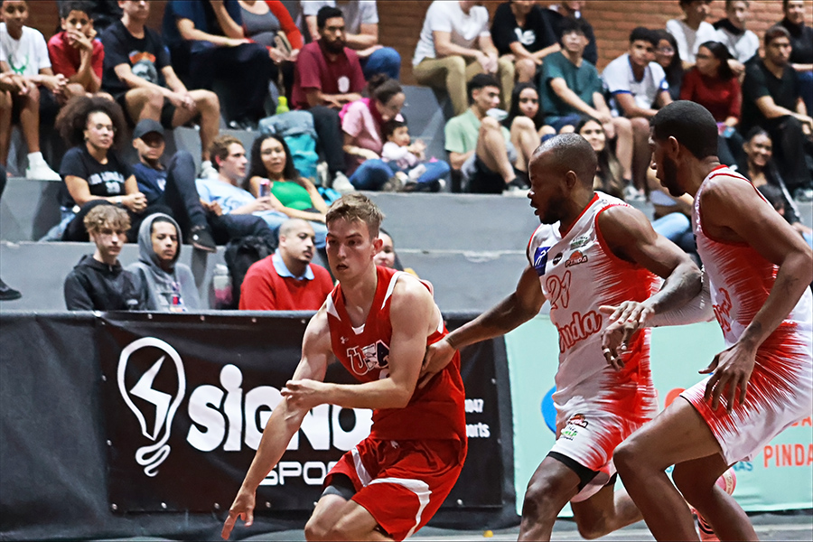 Logan Wendell, senior guard for the Ithaca College men's basketball team, spent 10 days in Brazil playing basketball. In the photo, Wendell drives past two defenders to get to the rim.