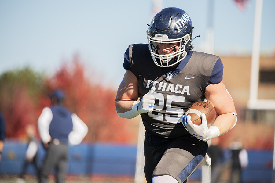 The Ithaca College men's soccer team faced back-to-back losses, while women's soccer, field hockey, football, volleyball, cross-country, and swimming and diving excelled with strong performances over the academic break. Pictured, junior tight end runs with the ball.