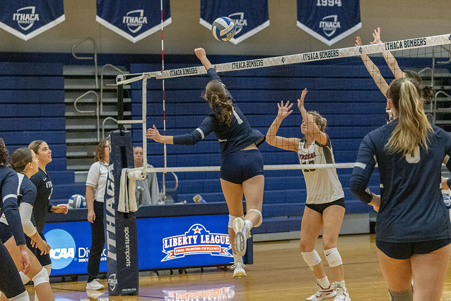 Senior middle blocker Josie Hampton attempts to spikes the ball over the net against Vassar College on Oct. 12. The Bombers won 3–1, despite dropping the third set.