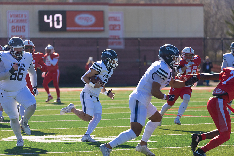 Senior running back Jake Williams runs down the field with multiple blockers in front of him.