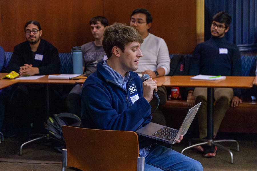 Junior Caleb Cackowski, vice president of communications, presents at the Nov. 4 town hall. Back row from left, Dante Conde Class of 2026 Senator, sophomore Evan Wasserman, School of Music, Theater, and Dance Senator, and junior Baneet Pukhrambam, International Senator, Manan Maini, Class of 2028 Senator.