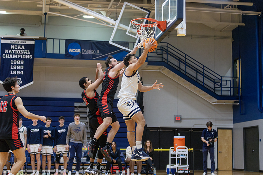 A Bombers player jumps up to grab a rebound surrounded by Raptors players on the defensive end of the floor.