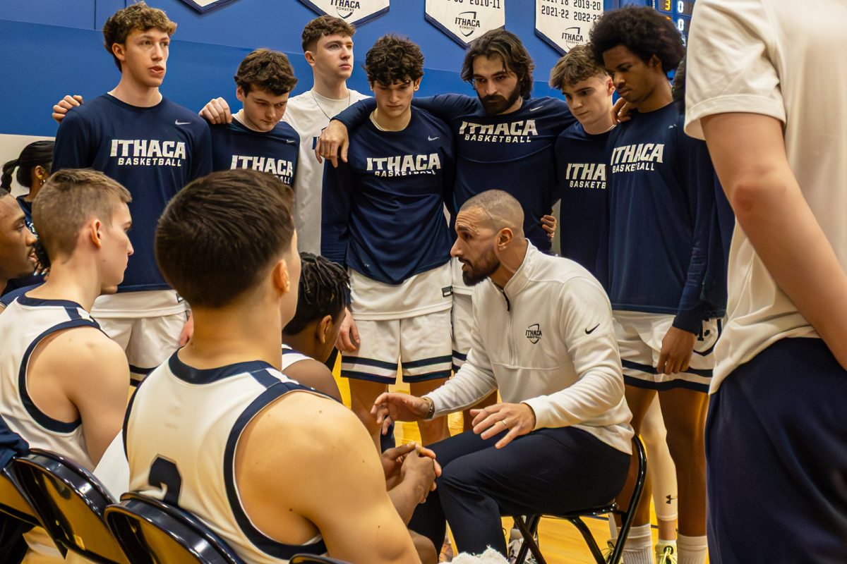 The Ithaca College men's basketball team advanced to the Liberty League championship game with a win over the St. Lawrence University Saints Feb. 28. The team huddles around head coach Waleed Farid during a timeout.