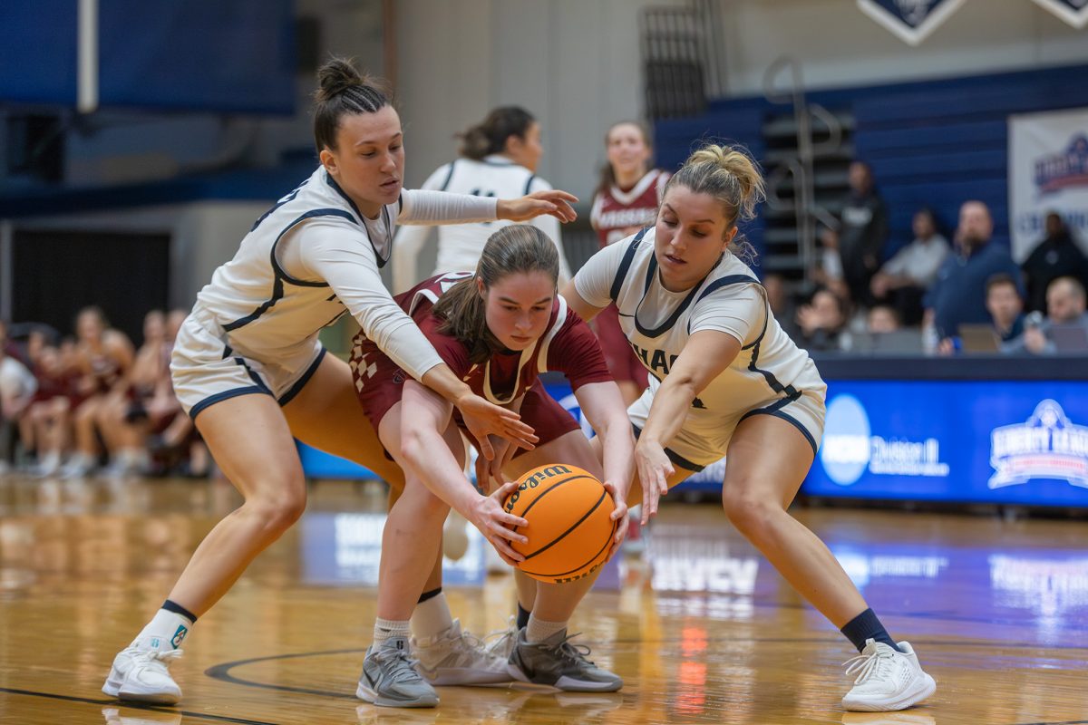 The Ithaca College women's basektball team fell to the Vassar College Brewers in the Liberty League championship game. Two Bomber defenders try to strip the ball away from the RIT player.