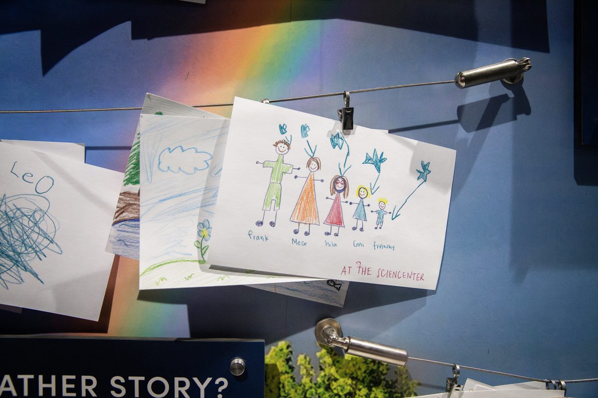 At the Sciencenter, there are interactive exhibits that allow visitors to create and have tactile experiences. At the weather exhibit, a child drew a photo of their family. 