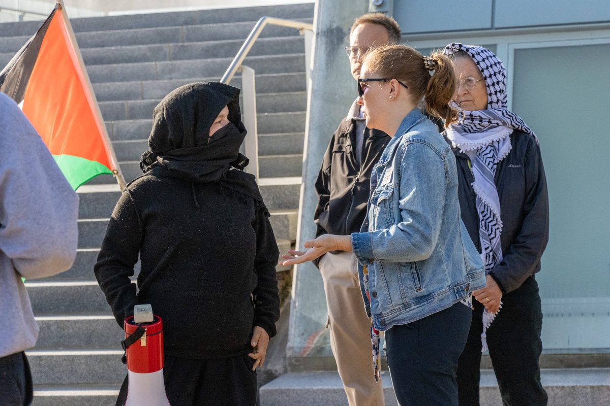 Rebecca Cogan Carroll, director of ICare and Student Support, confronts the group of protestors outside of the Peggy Ryan Williams Center. Cogan Carroll issued a noise complaint at 8:47 a.m. to the protestors. 