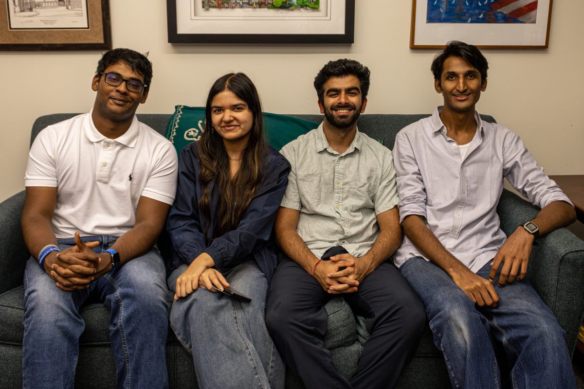 Four students on the e-board for the South Asian Student Association sit on a couch smiling for a photo.