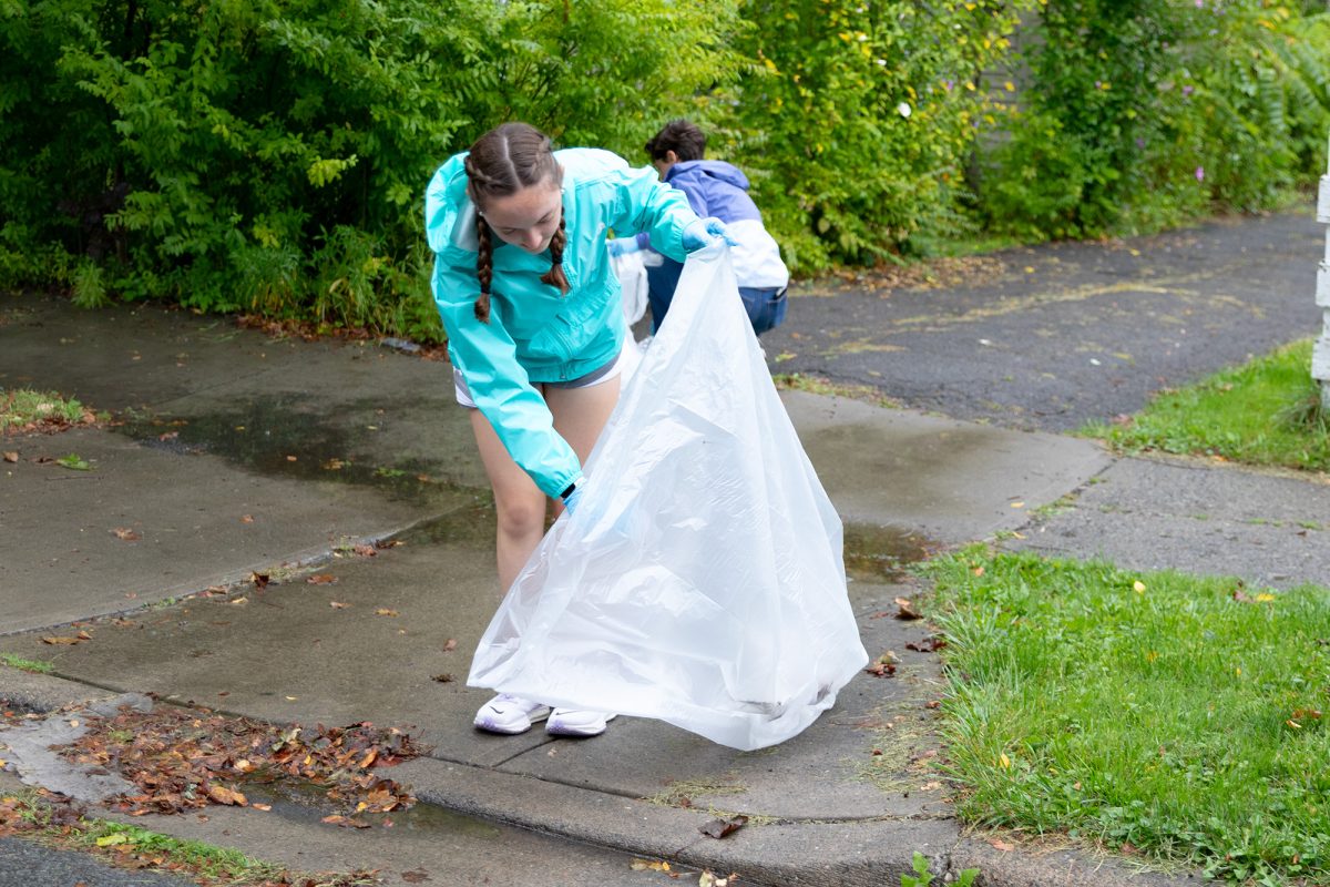 Sophomore Molly Davey assists in cleaning up the environment Sept. 6 on Hudson Street at IC Eco Reps’ South Hill September Clean Up event.