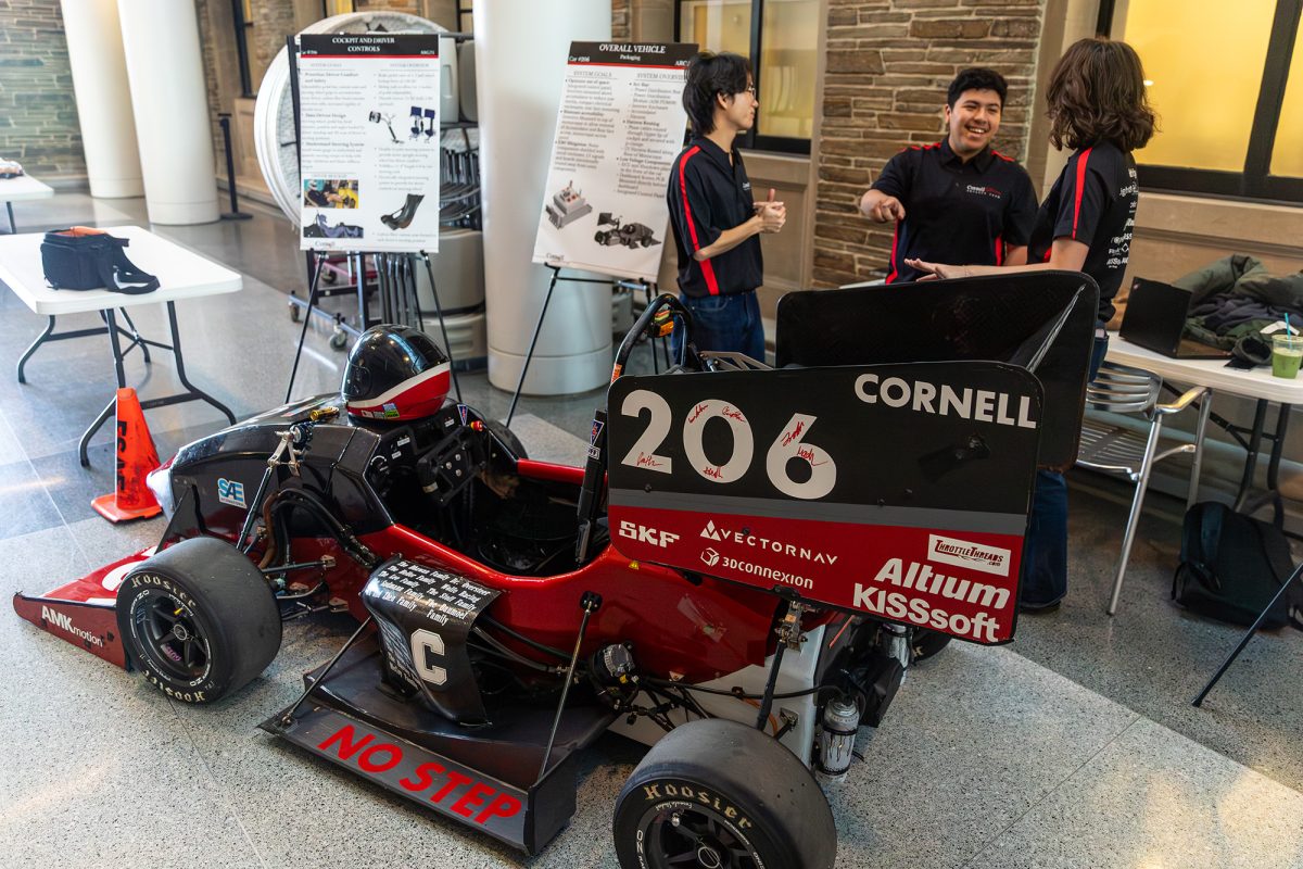 From left, Cornell graduate Ryan Lee and seniors Jacob Gonzalez and Jolene Gagliano stand over the ARG25, the Cornell Racing Formula Society of Automotive Engineers' newest car.