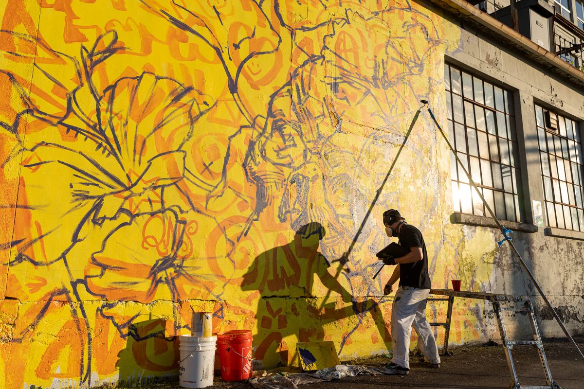 Utica-based artist, Tony Lopez, creates a striking mural on an abandoned factory wall during Ithaca's Mural Jam on Oct. 3. 