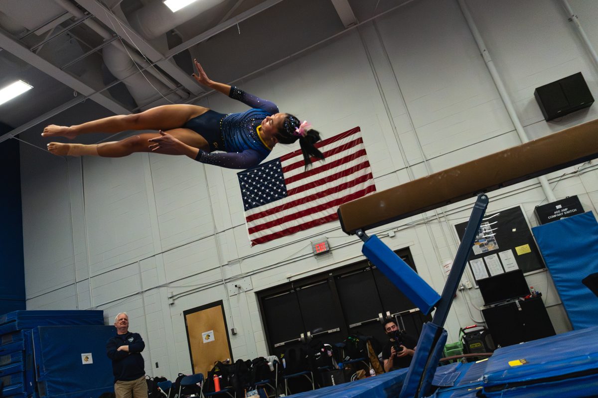 Senior Corey Foster dismounts on her balance beam routine. Despite the loss Feb. 8, the Bombers celebrated their five seniors, including Foster. 