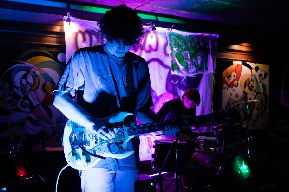 Senior Zach Ryan and guitarist for little slicer, takes the stage for the first show of the band’s anniversary weekend at the Nocturnal Café on Feb. 20. Between songs, band members shared anecdotes of their time together playing shows and recording their two EPs. 