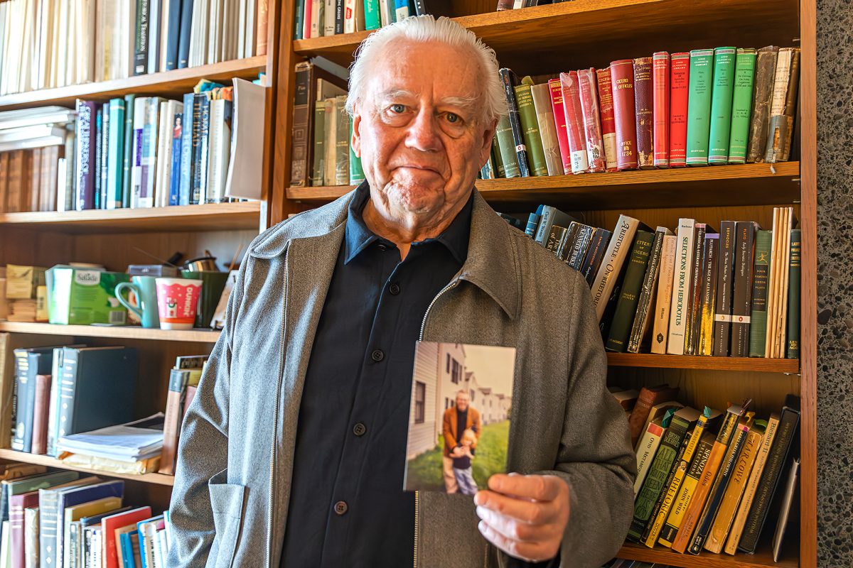 Bob Sullivan, professor in the Department of Literatures in English at Ithaca College, shows a photo of himself and his daughter Ava attending a student organization event at the Circle Apartments in 1996.