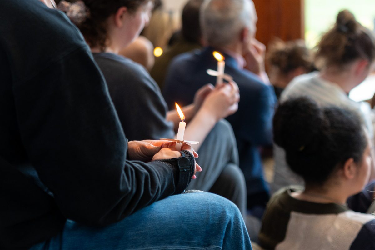 Community members lighting candles in Everett Joseph Moore's honor.