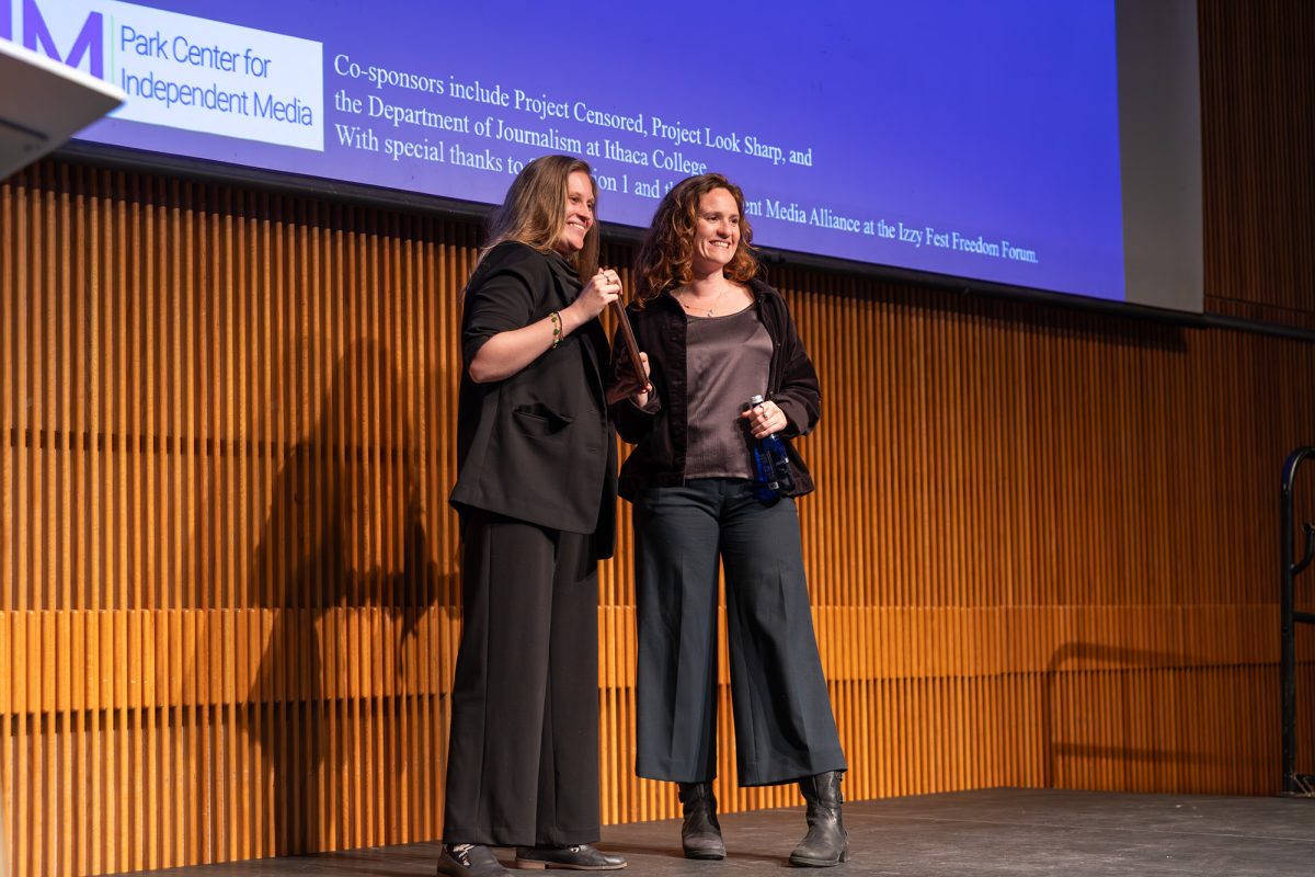 Vivian Rose '25, research assistant at the PCIM and former editor at The Ithacan, presents Gwynne Hogan of The City with an Izzy Award. 